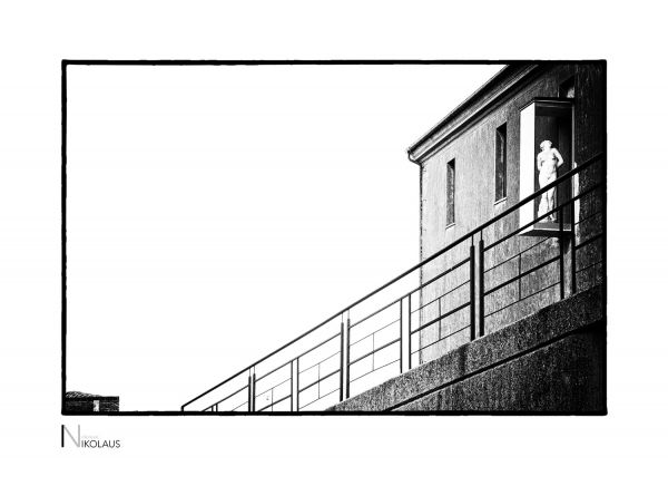 Glaskasten mit klassischer Aktskulptur an der Burgfassade Savona